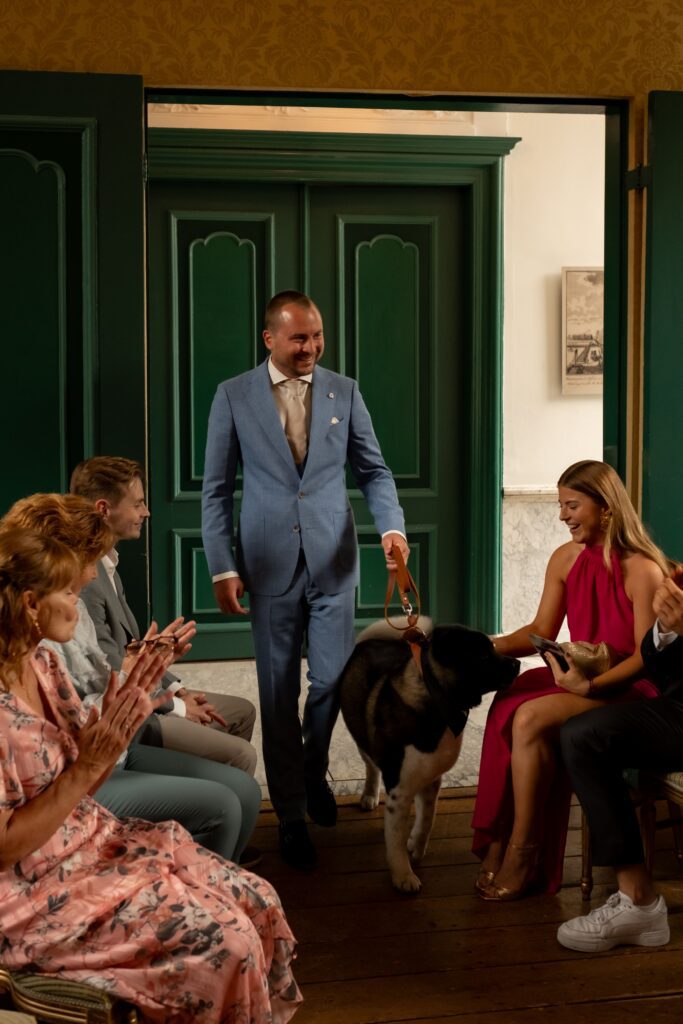 Aankomst bruidegom met hond tijdens ceremonie bruiloft Amsterdam
