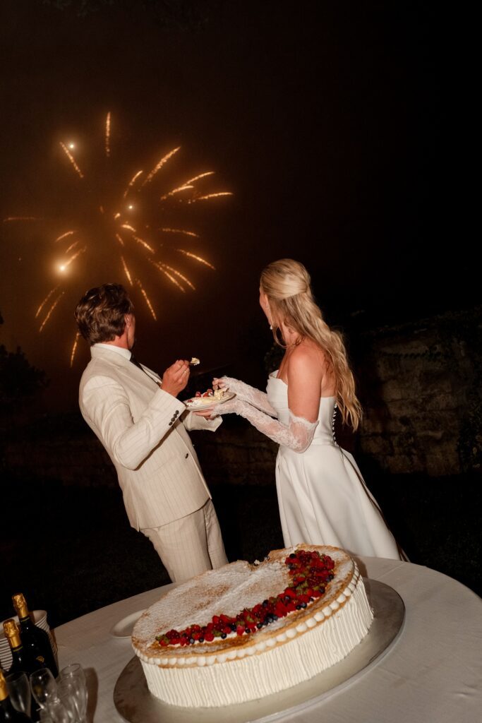 koppel eet taart en kijkt naar vuurwerk trouwweekend italie
